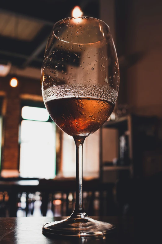 a glass of wine on a table in a dark room