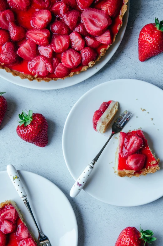 a slice of pie sitting on plates with strawberries and strawberries