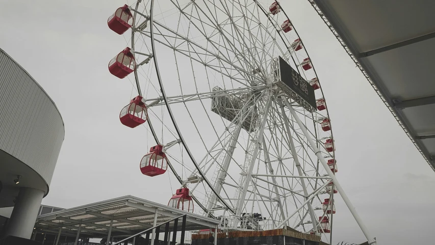 a large ferris wheel near some buildings on a cloudy day