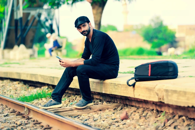 a man sitting on the rail with his phone