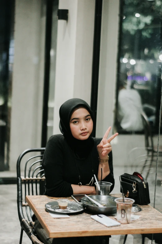 a woman is sitting at an outdoor table with food