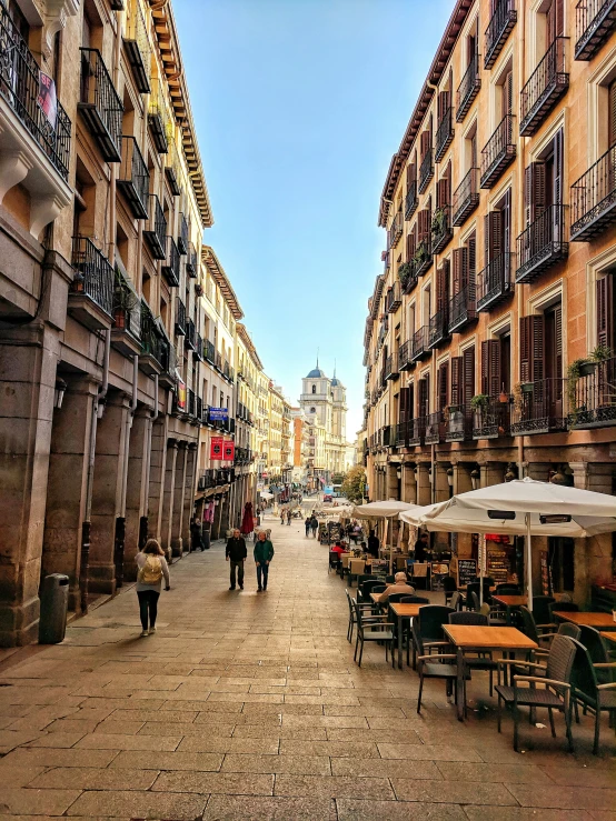 people walking along a city street under an umbrella