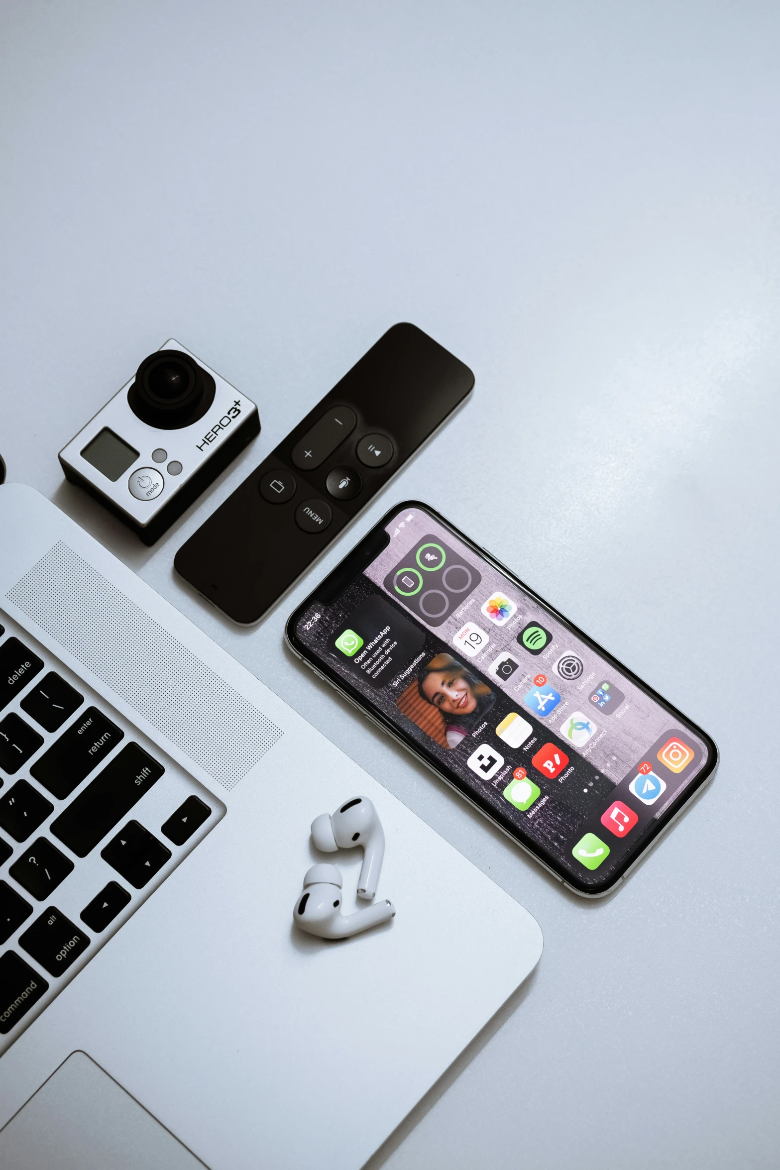 a table with an iphone, headphones, and other electronics