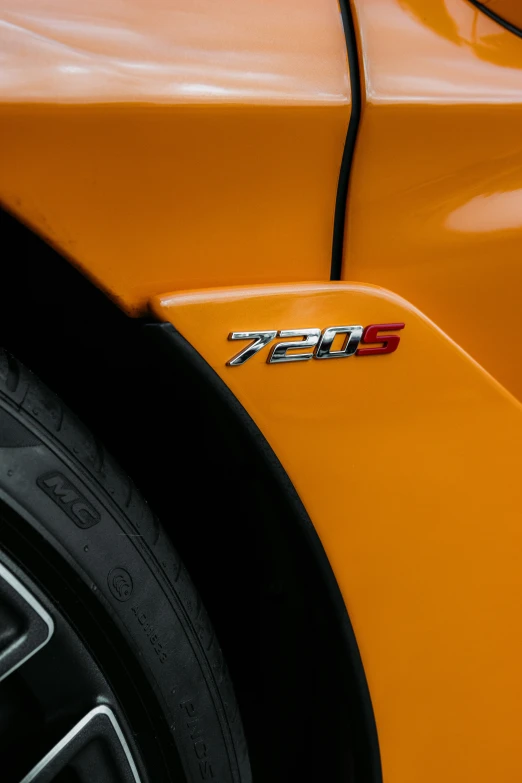 the front end and emblem of an orange car