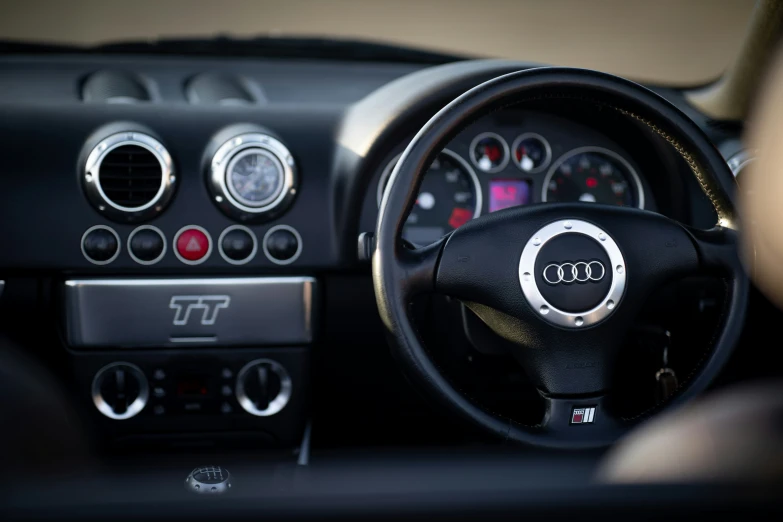 steering wheel and dashboard of a small, black - colored car