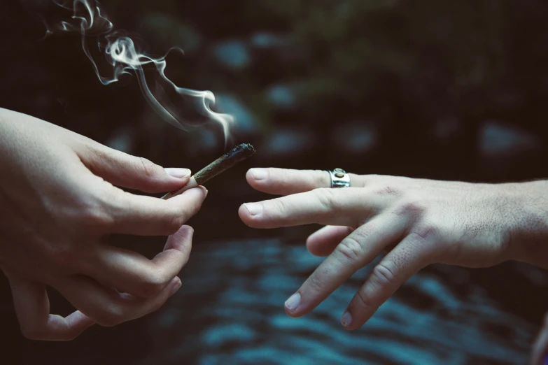 two hands are shown holding up the lighter as they both hold one