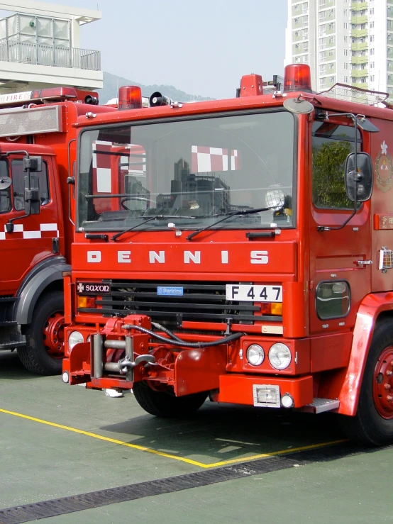 two large red fire trucks parked in a parking lot