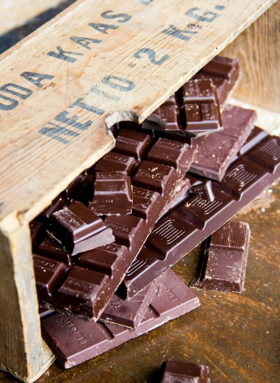 a wooden crate filled with chocolate pieces covered in melted sugar