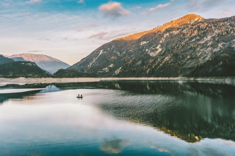 a mountain and a lake with a boat floating