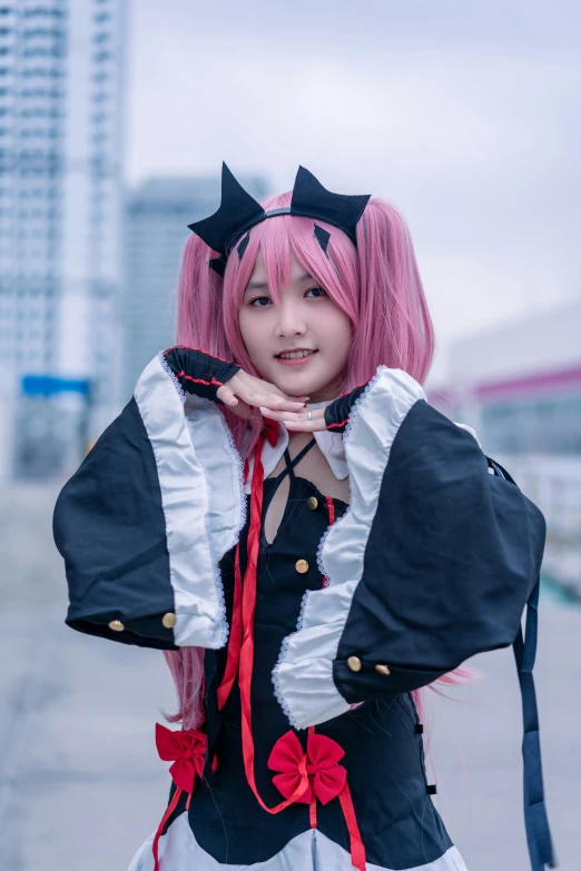 a woman with pink hair, black and white jacket, and red bow - tie posing for a po