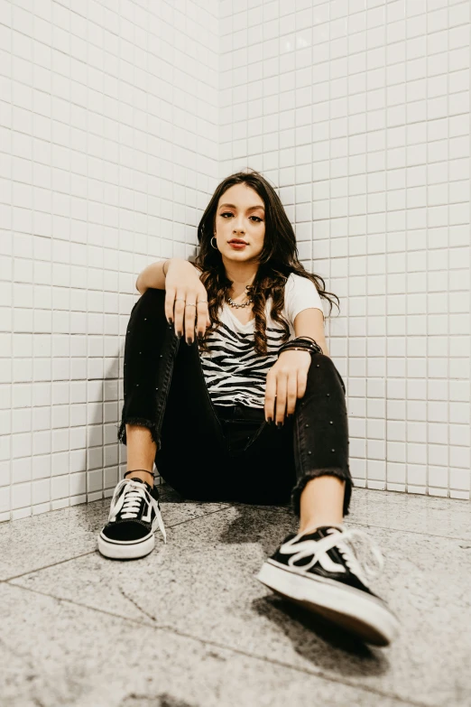 a girl sitting on the ground with her legs crossed