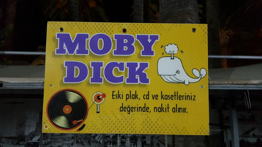 a sign for moby  shows a large vinyl record and cartoon character