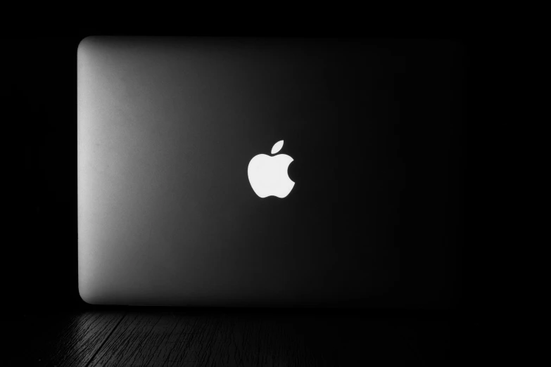 an apple laptop in black with apple logo on it