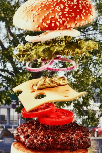 a triple stacked hamburger sandwich is above some other food items
