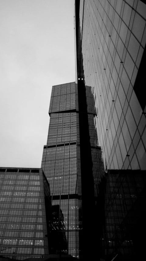 two very tall buildings with many windows next to each other