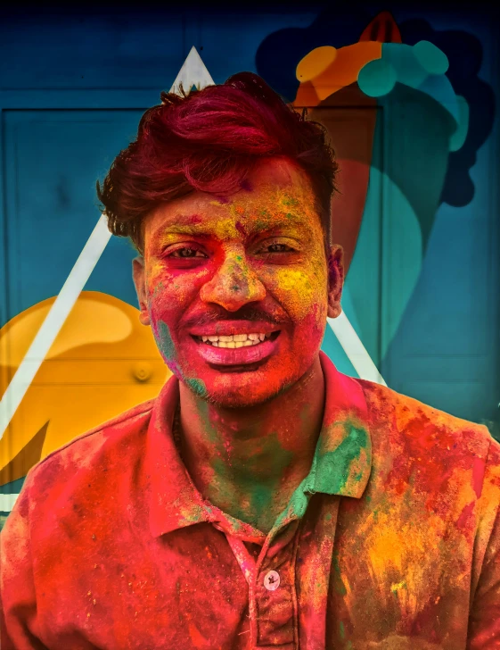 a man covered in colored paint, posing for a picture