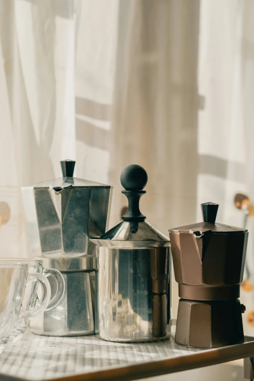 pots are sitting in front of a coffee maker