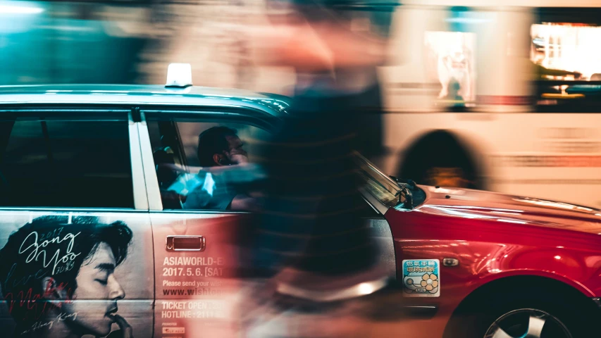 a woman driving through the streets with an advertiser on the side of her car