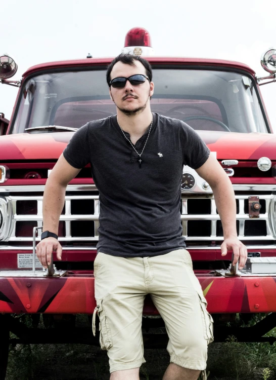 a man is sitting on the front bumper of an old fire truck