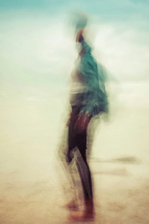 blurry pograph of a man walking on the beach