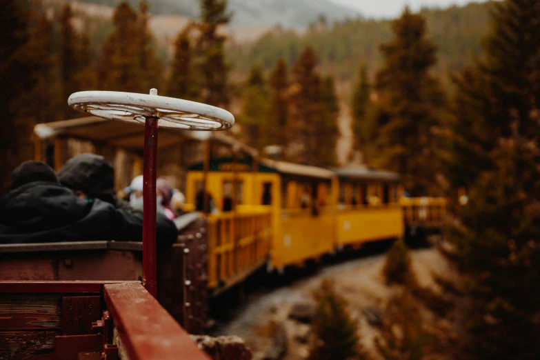 people on the side of train next to mountains