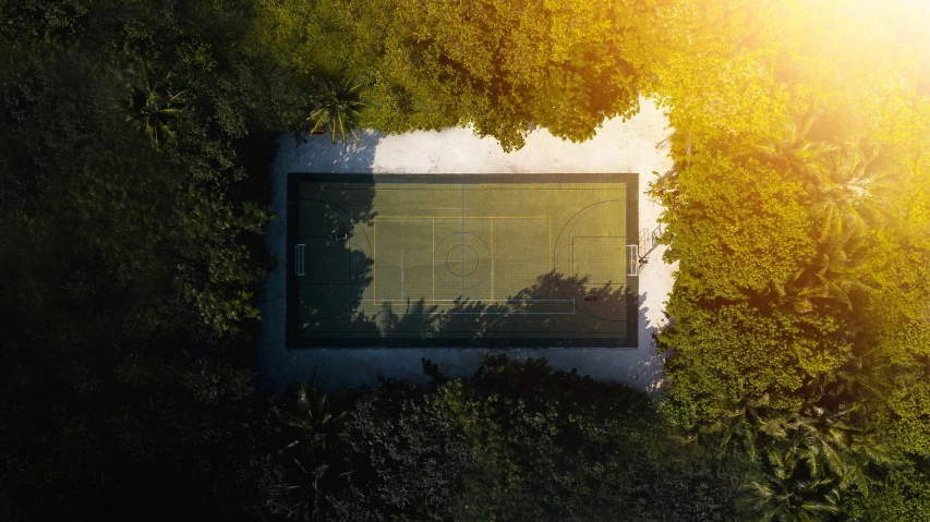 a tennis court that is in between some trees