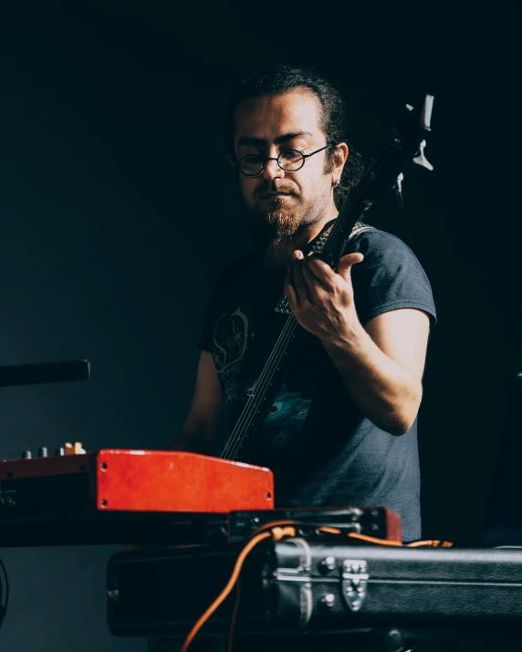 an image of a man playing guitar at a recording studio