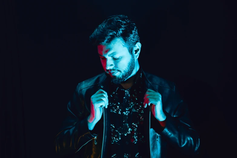 a man in leather coat holding a chain around his neck