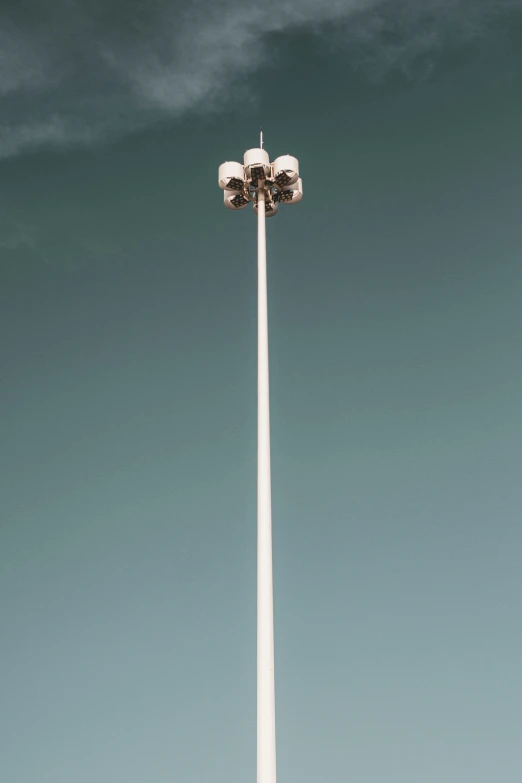 a couple of people are standing underneath a tall light pole