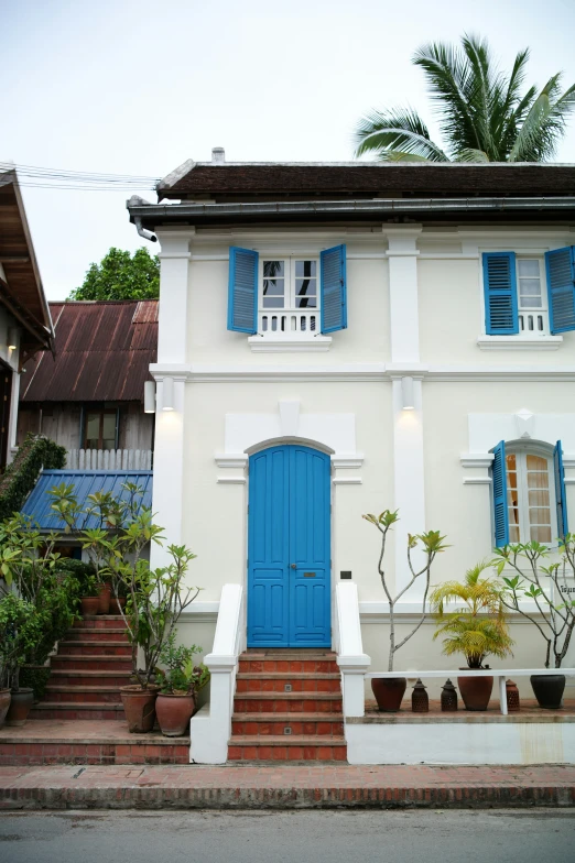 an elegant home with blue shutters and a blue door