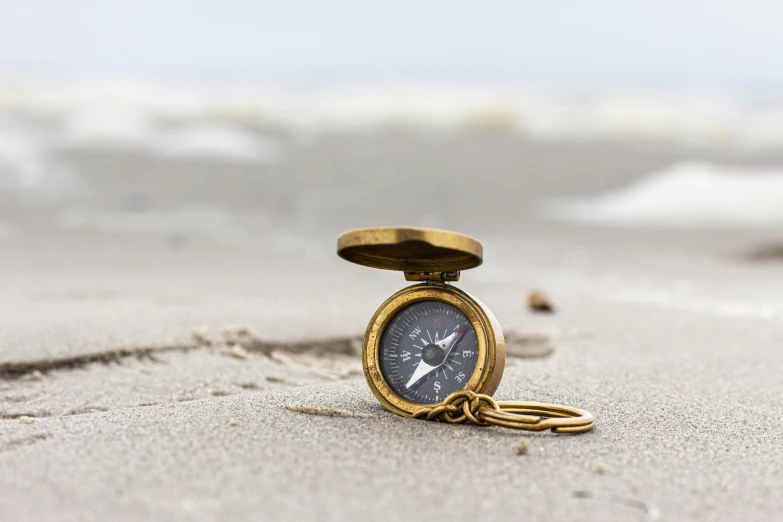 the clock is in the sand with sand in front