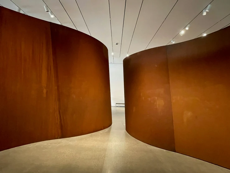 a long orange wall is between two large brown walls