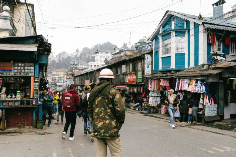 people walking around an open street near buildings