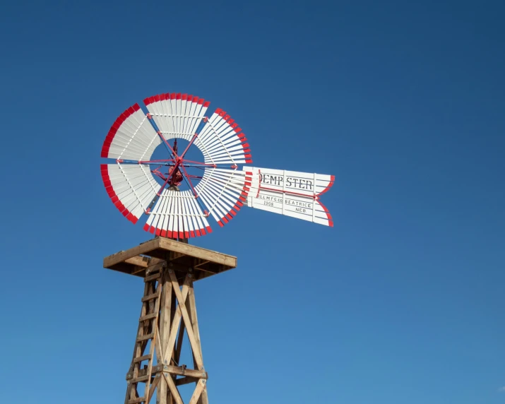 a large wooden water tower with a large metal windmill on top