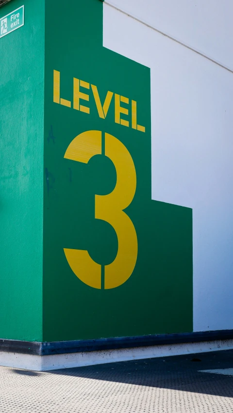 a street sign that reads level 3 and is green and yellow