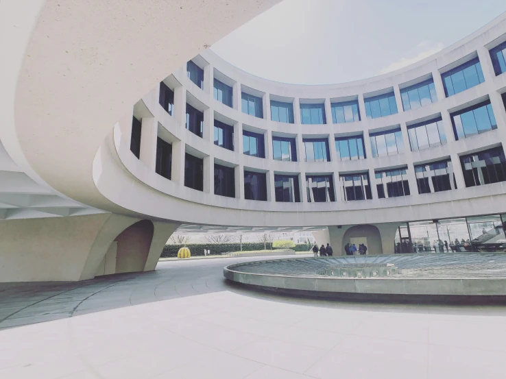 there is a circular building that has a walkway below it