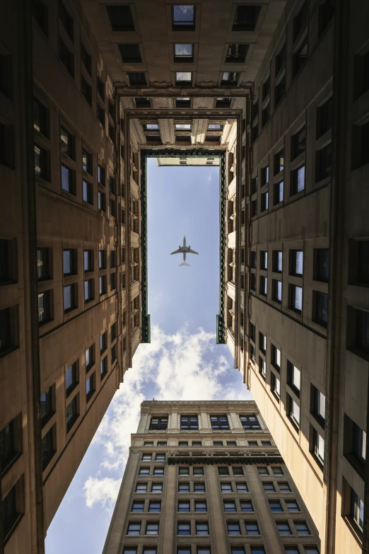 an airplane that is flying in the sky above some buildings