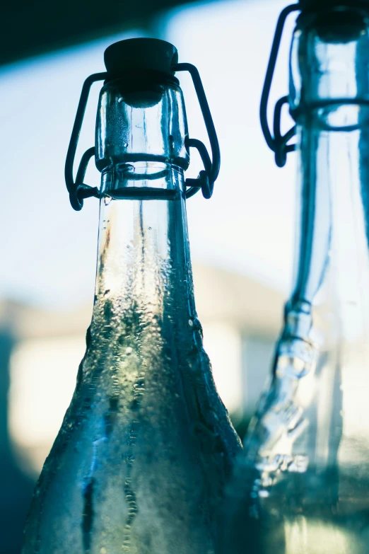 two empty beer bottles sit in front of one another