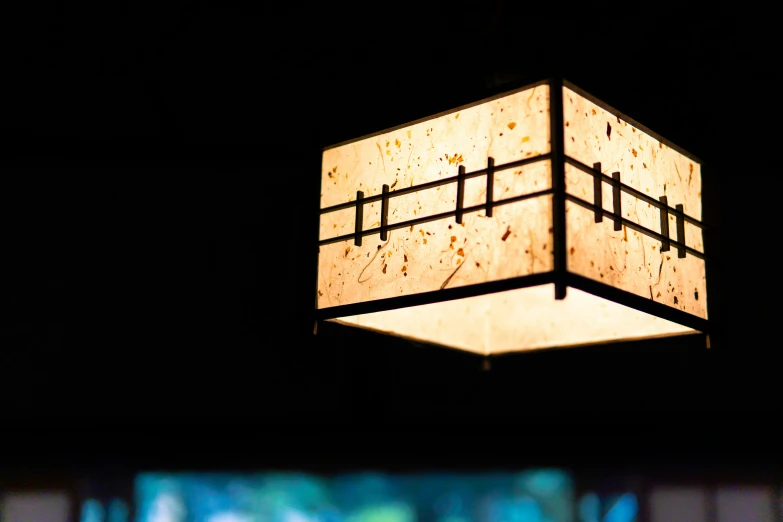 an odd square light fixture suspended in the dark