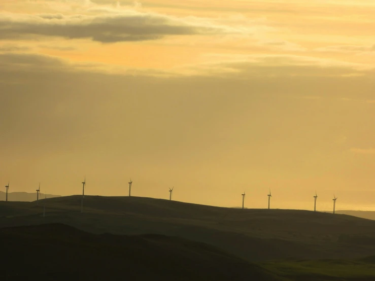 a row of windmills sitting on top of a hill