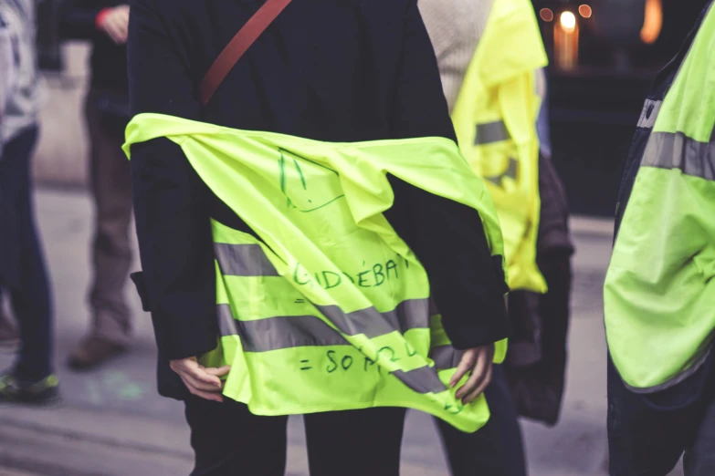 several people standing around in safety vests and holding onto each other