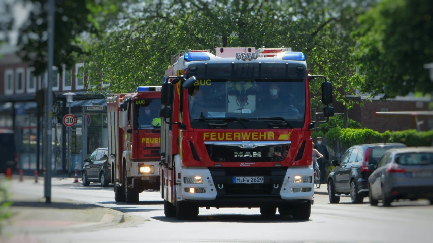 red truck parked next to a red fire truck in the middle of the street