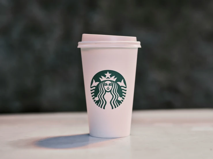 a white cup with the word starbucks on it