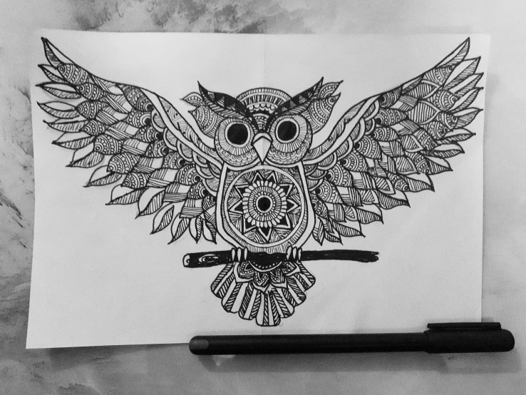 an owl made from an ornamental pattern on white paper