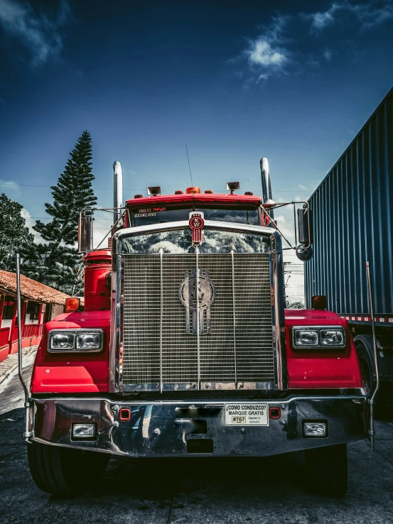 red truck parked in front of a shipping container