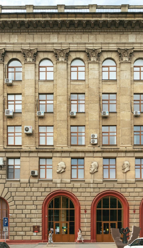 the car is parked near the very large building