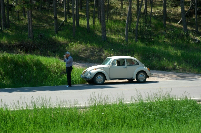 a woman looks at her car and another woman stands beside her