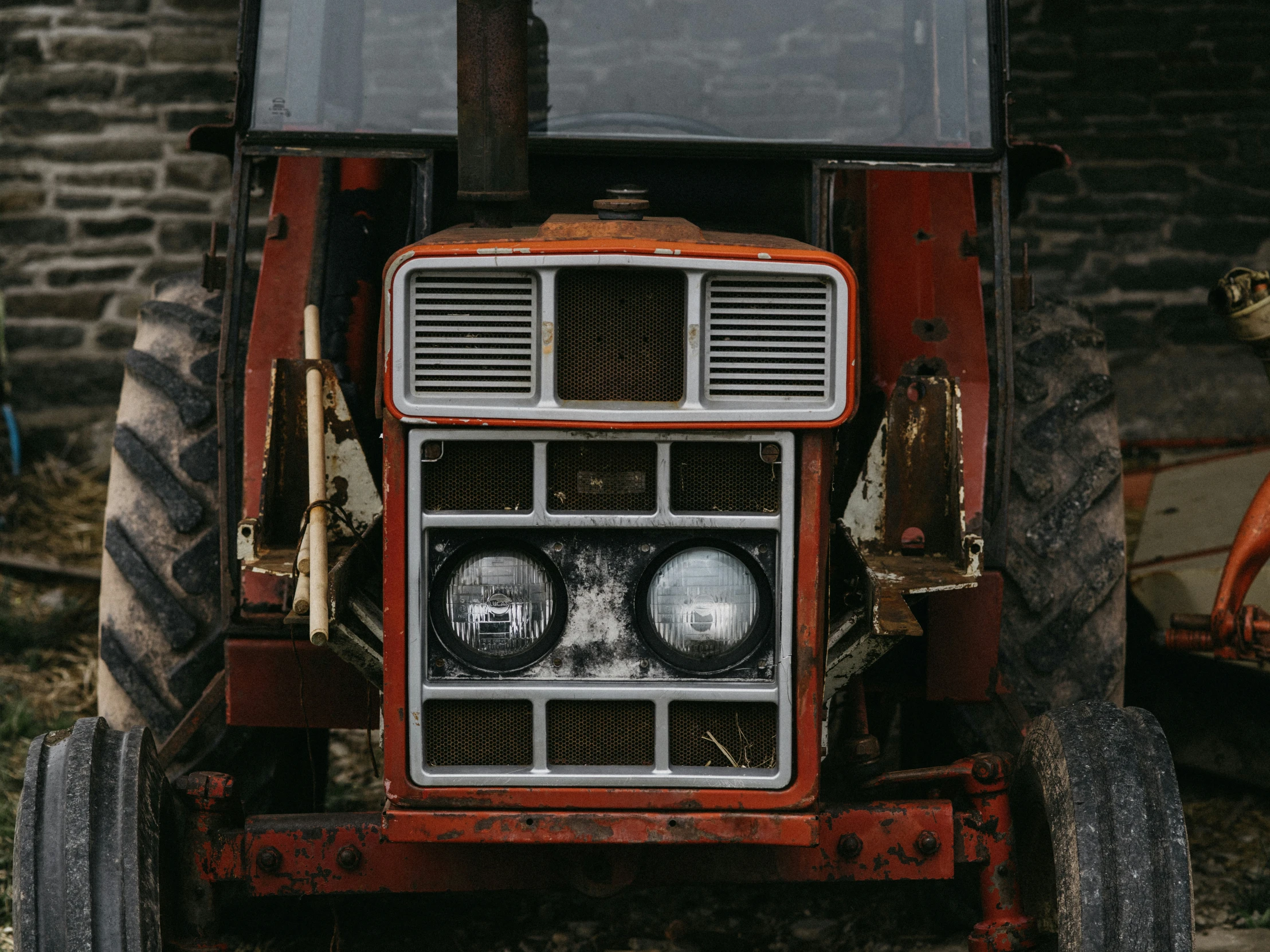 an old red tractor with some big tires