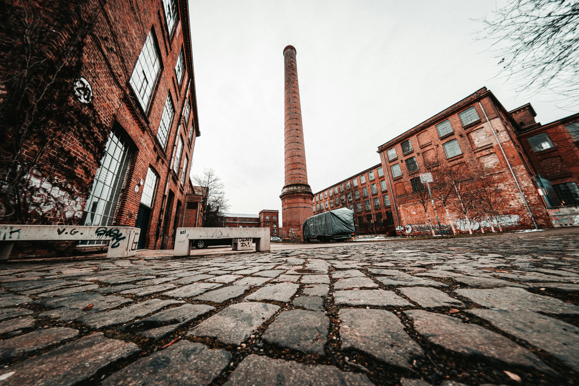 bricked building with a large iron chimney in the background