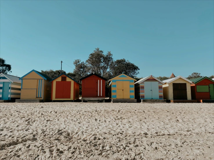 a row of beach huts lined up in the sand